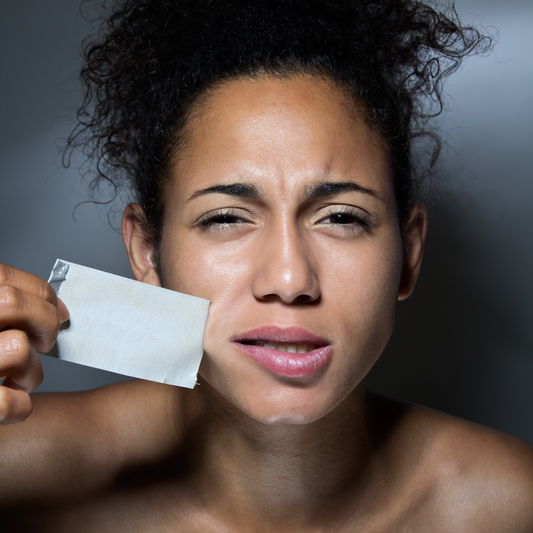 black woman with mouth covered